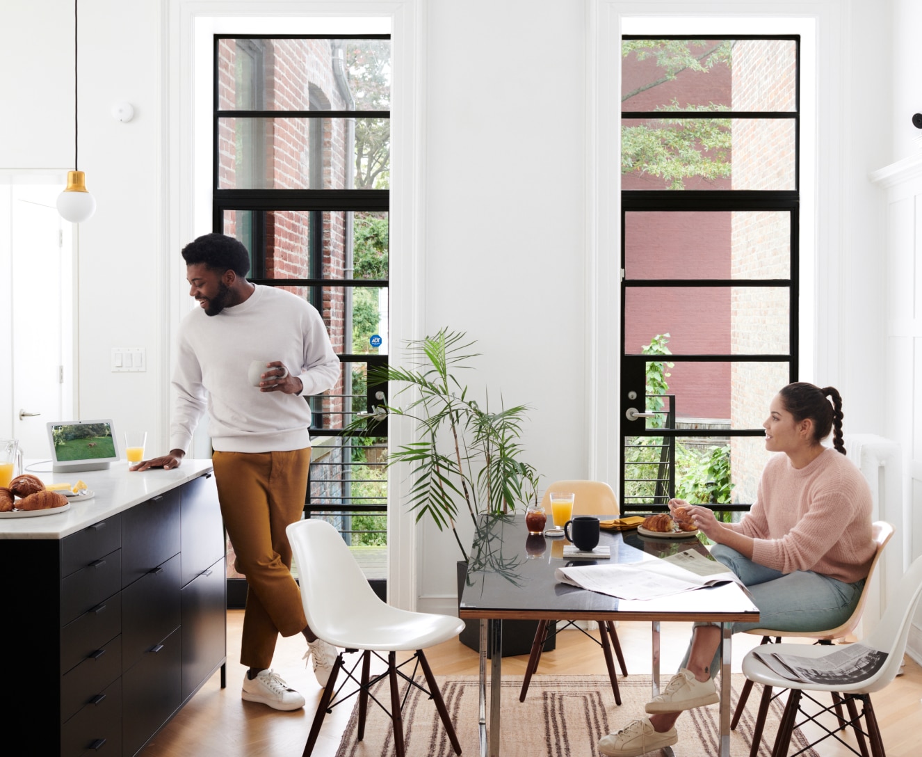 Couple in their living room with Google Nest Hub Max on the table Couple in their living room with Google Nest Hub Max on the table