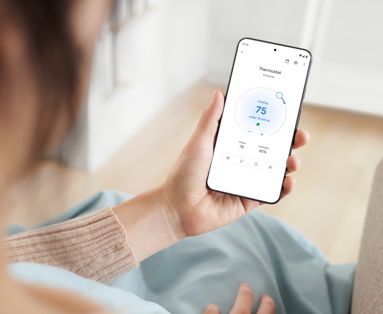 Person controlling their Google Nest thermostat from their phone