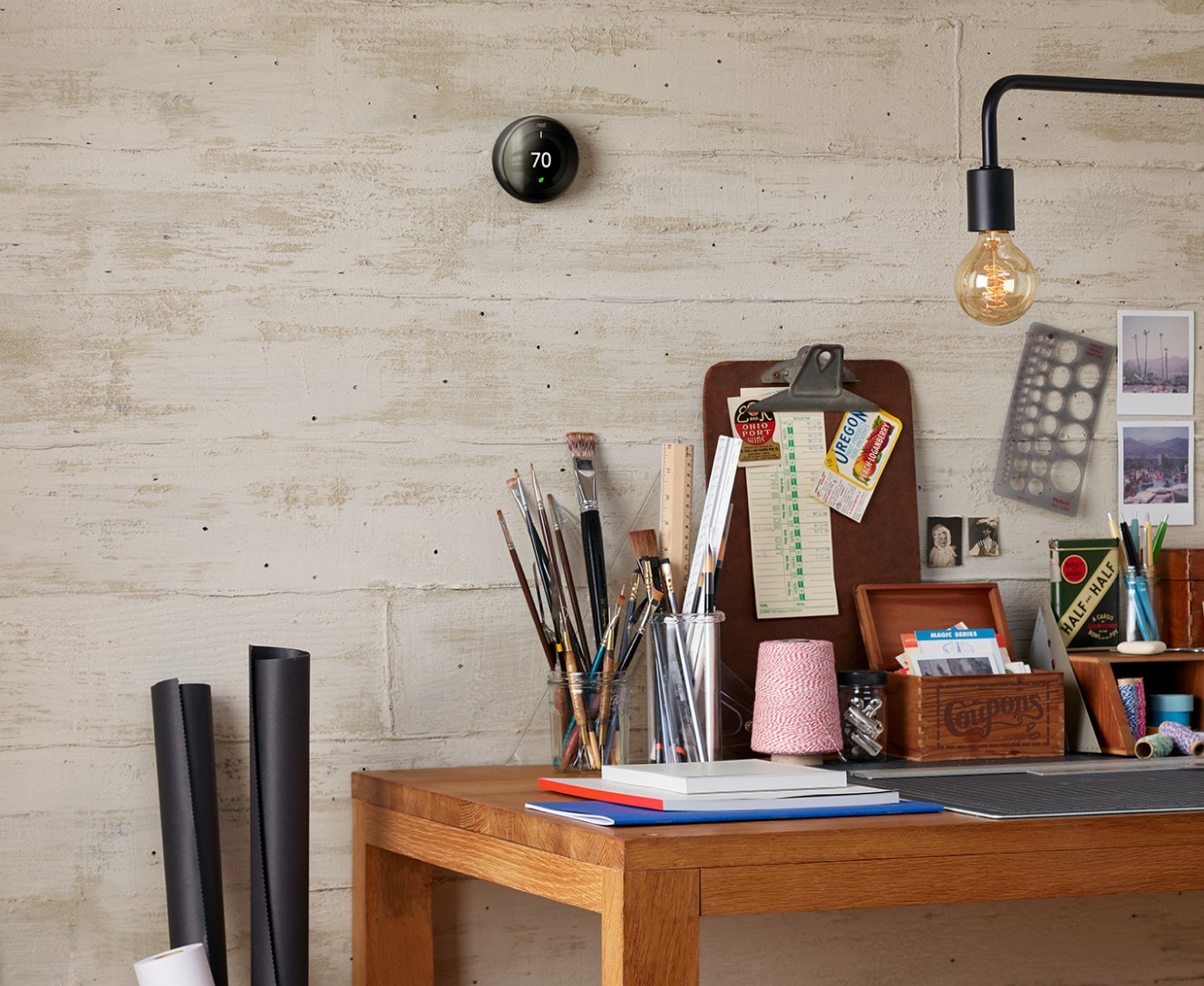 A work desk with Google Nest Learning Thermostat on the wall above it