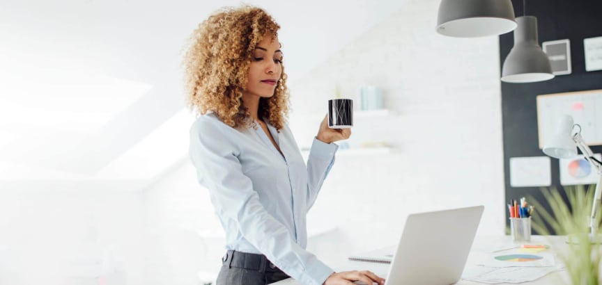Women working on her laptop while drinking coffee