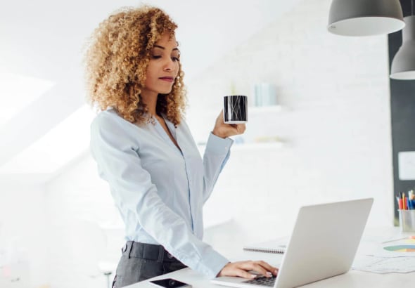 Women working on her laptop while drinking coffee