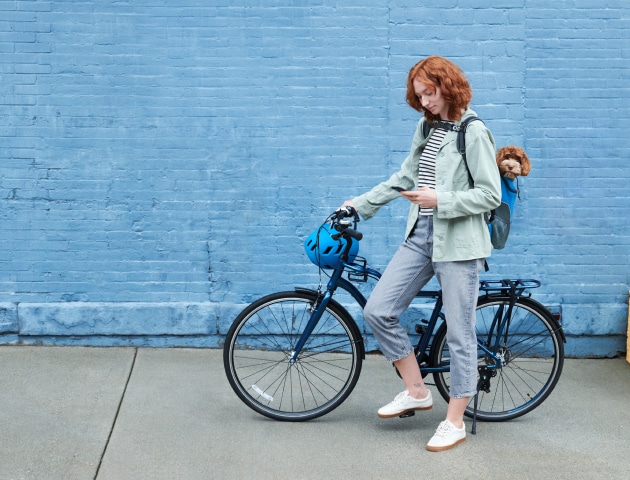 Women on a bike using the ADT+ app on her phone