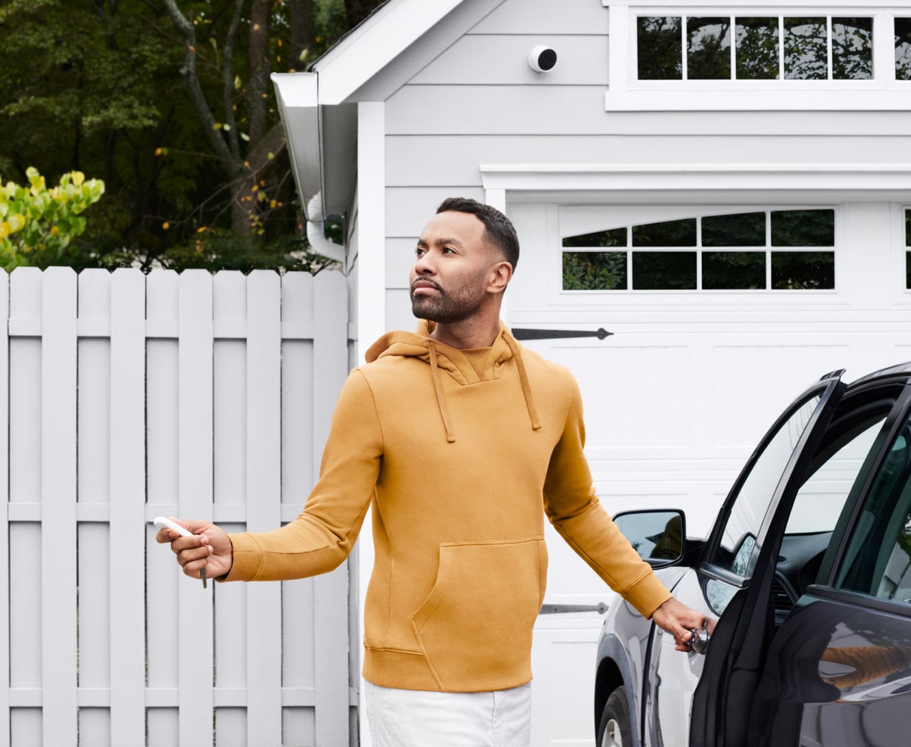 Man in driveway using his phone to check ADT survelliance on the ADT app Man in driveway using his phone to check ADT survelliance on the ADT app