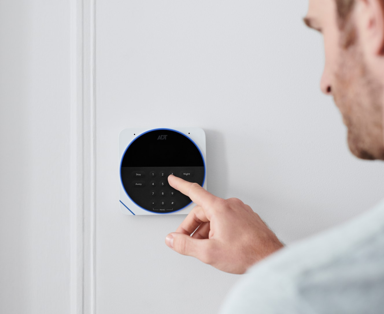 Man touching the ADT Keypad in his home