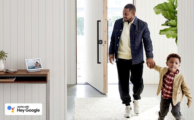 Father and child walking into room with Google Nest Hub on table Father and child walking into room with Google Nest Hub on table