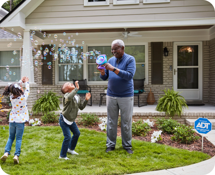 Family in front of ADT protected home playing with bubbles