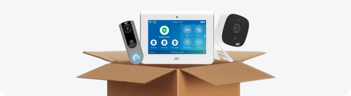 ADT doorbell camera, command panel, and indoor camera inside a cardboard box