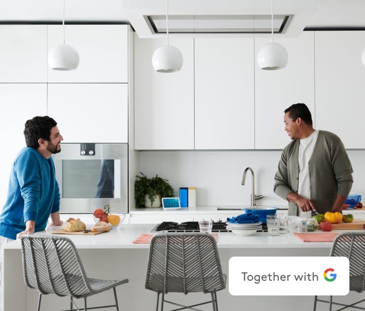 Couple standing in their kitchen with ADT devices
