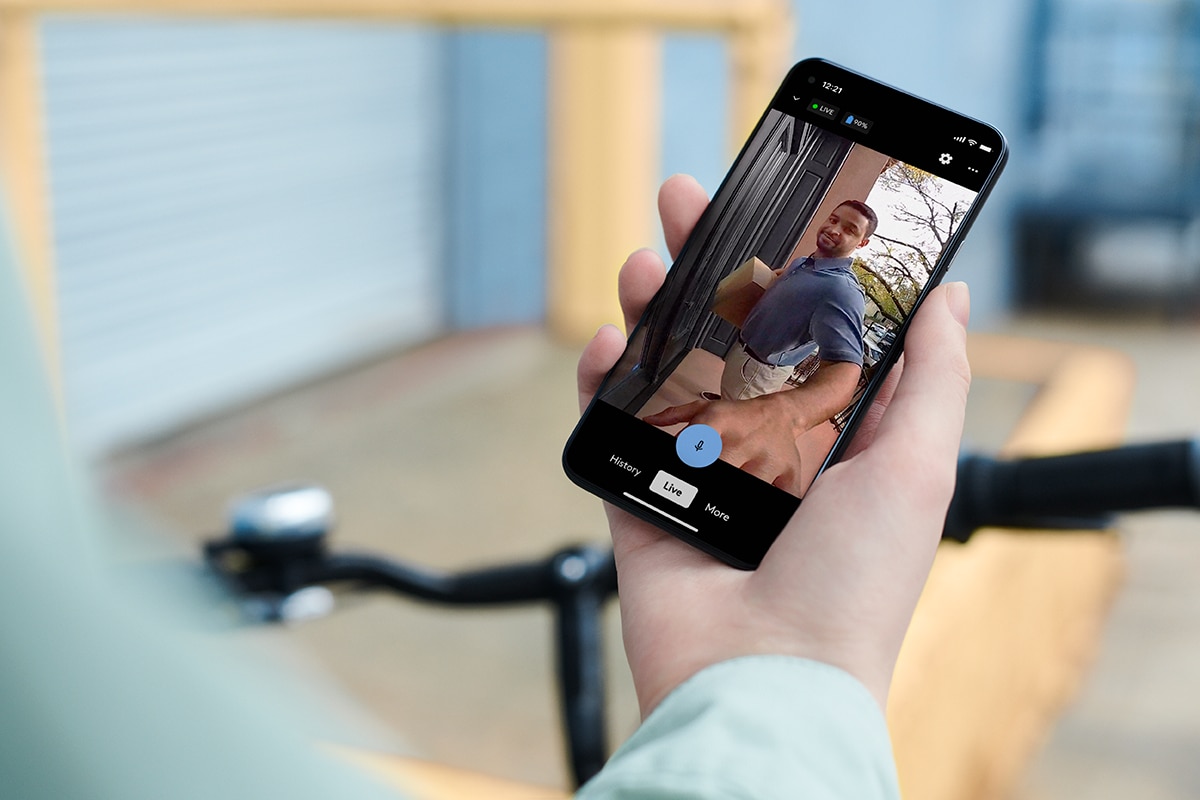 Hand holding a phone showing footage on the ADT app