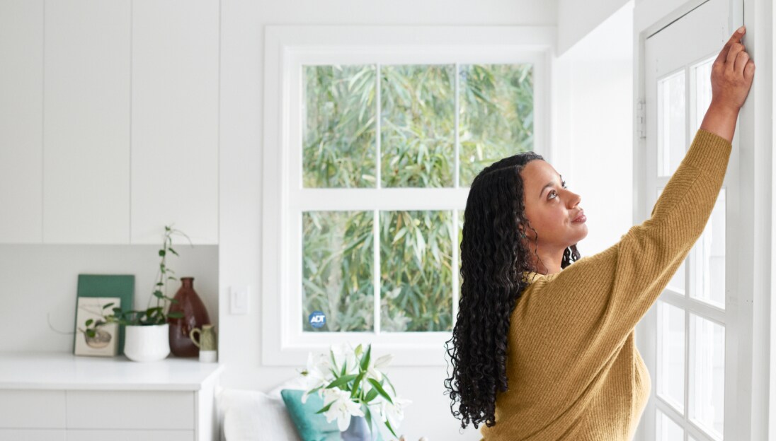 Woman adding an ADT security sensor to her door
