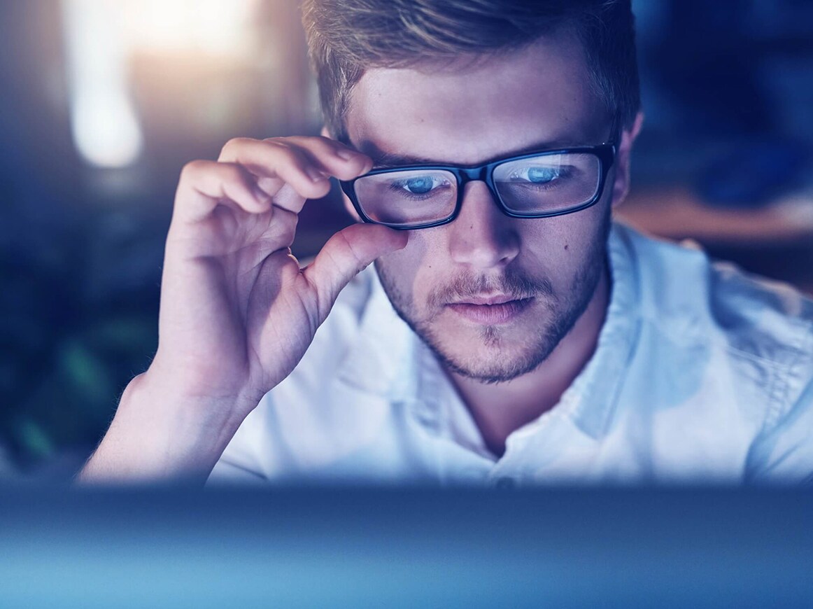 Man with glasses looking at computer Man with glasses looking at computer
