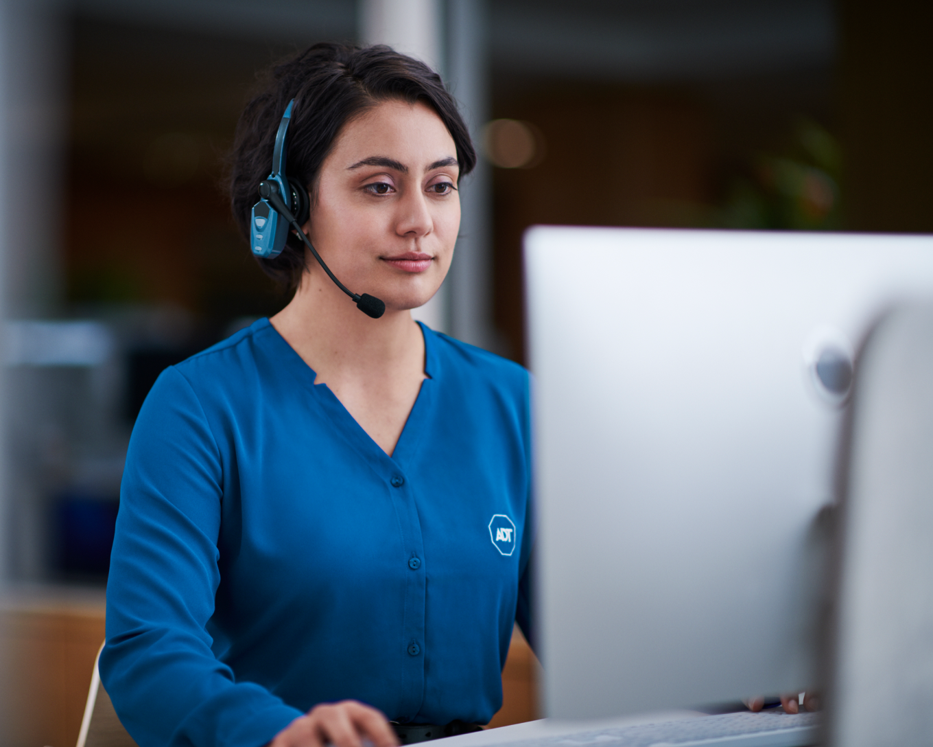 ADT call center employee working and talking into a headset 