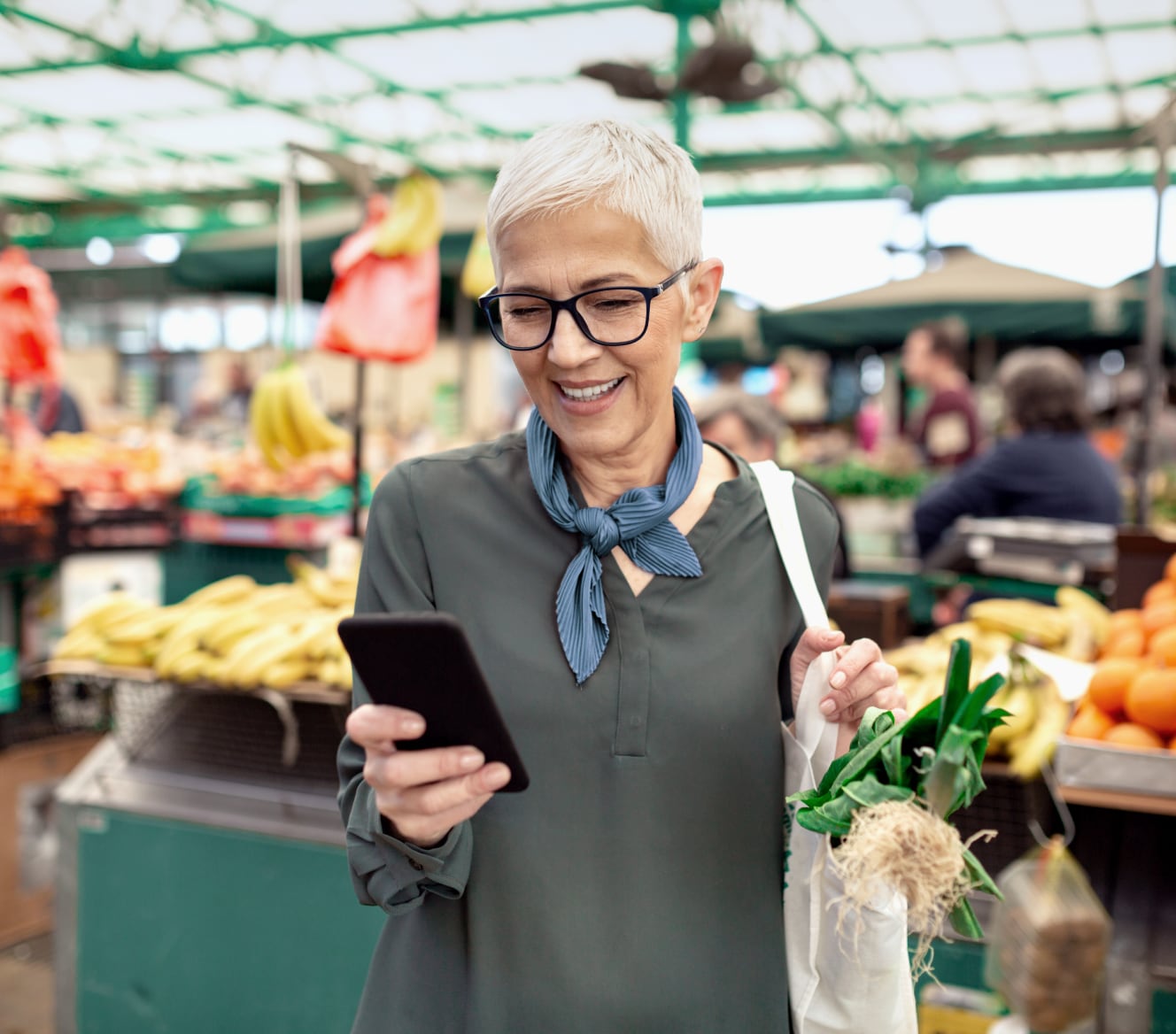 Woman using the ADT app on her phone in the grocery store Woman using the ADT app on her phone in the grocery store