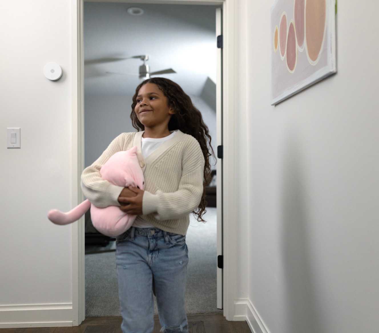 Niño entrando a su casa con una sirena interior ADT en la pared Niño entrando a su casa con una sirena interior ADT en la pared