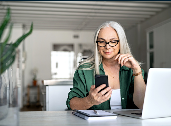 Woman looking at her ADT app on her phone in her home