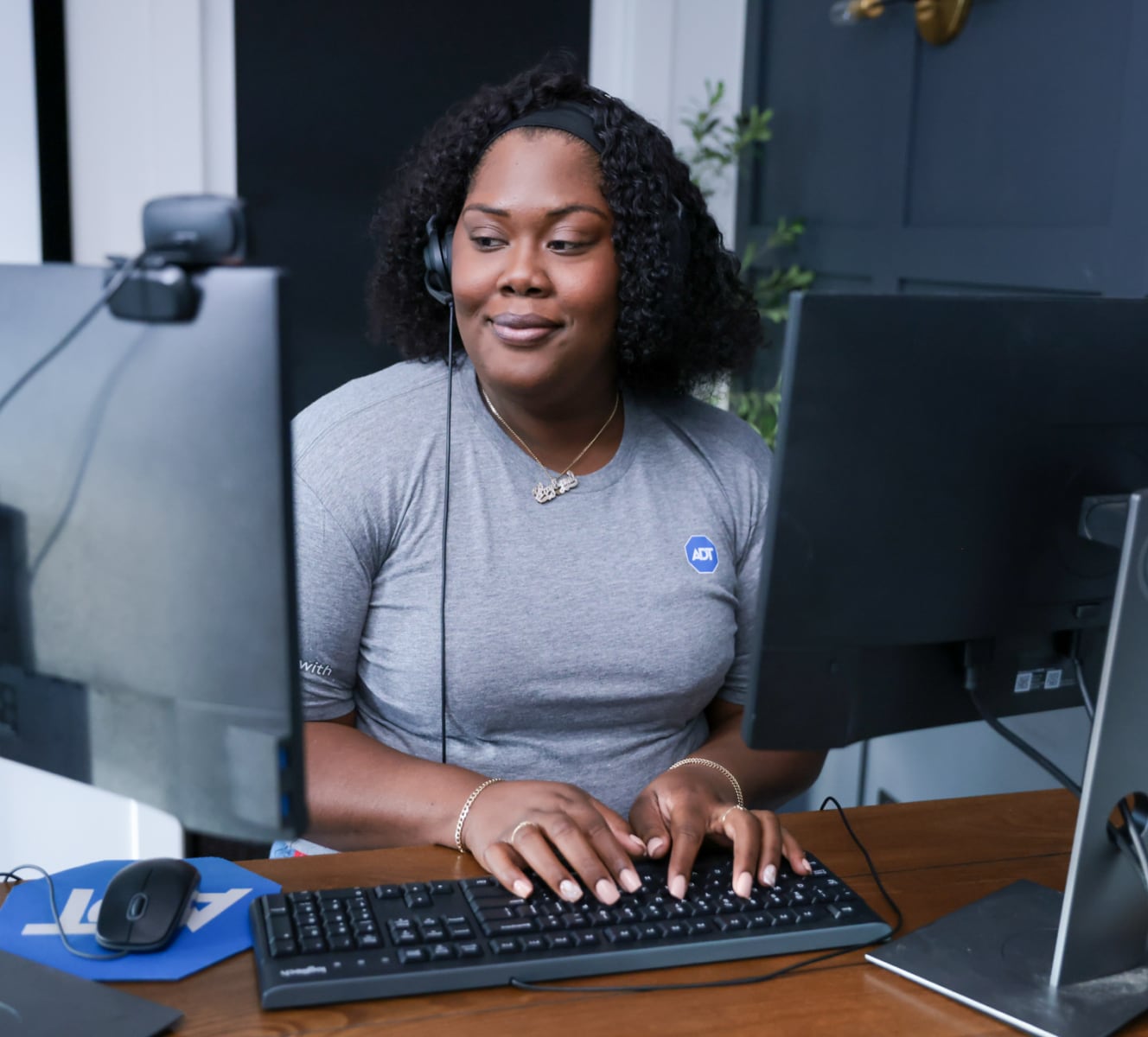 ADT customer service rep typing on her computer and troubleshooting with a customer 