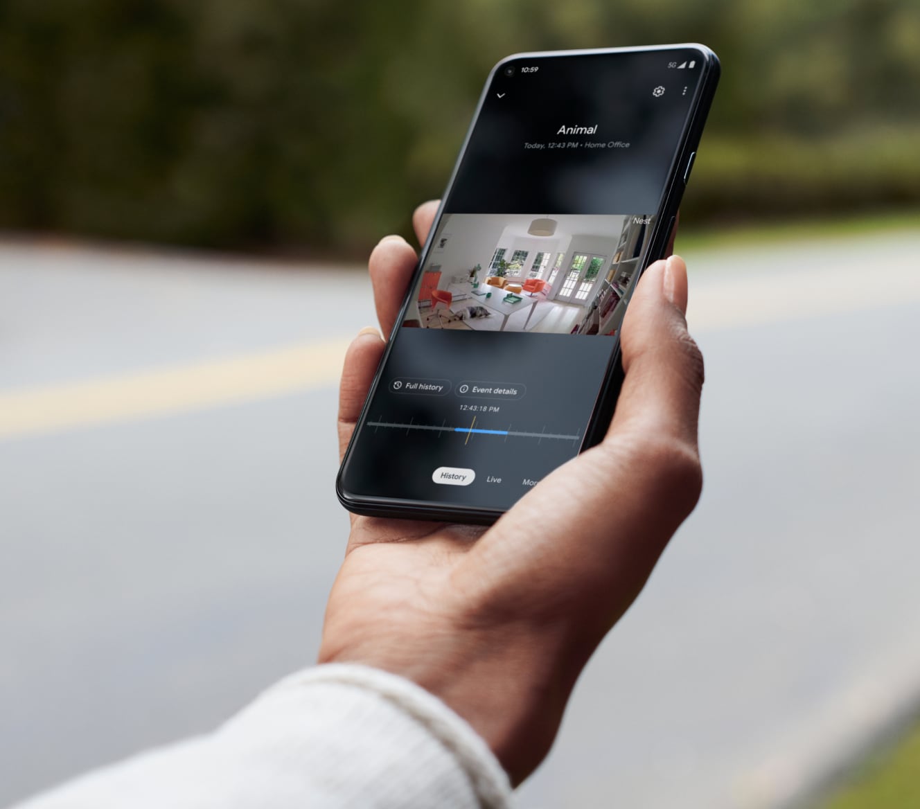 Hand holding a cell phone showing footage from his Google Nest Cam