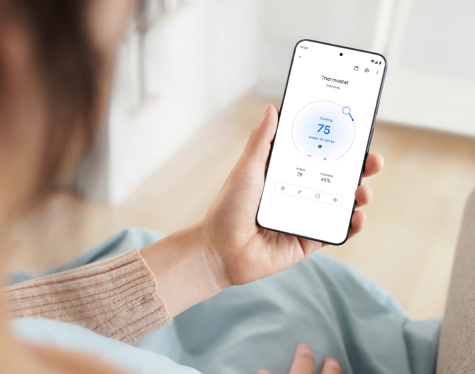 Woman adjusting her Google Nest Learning Thermostat using her cell phone