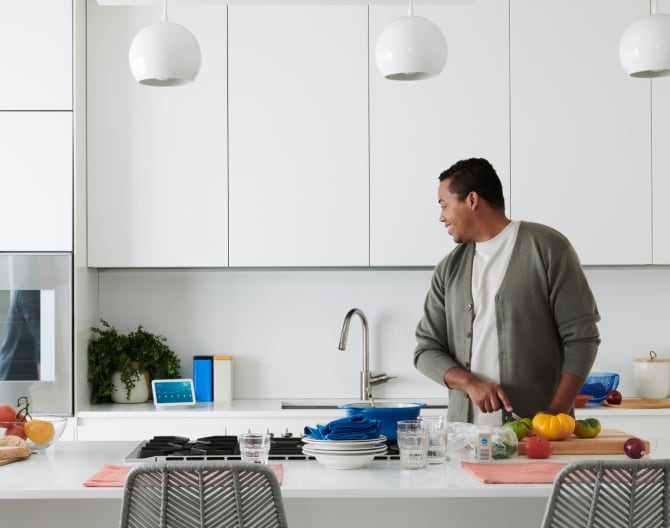 Man using voice control with his Google Nest Hub 2 Gen in the kitchen Man using voice control with his Google Nest Hub 2 Gen in the kitchen