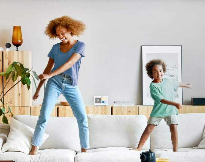 Women and her child jumping on the couch with the Google Nest Hub 2 Gen in the background Women and her child jumping on the couch with the Google Nest Hub 2 Gen in the background