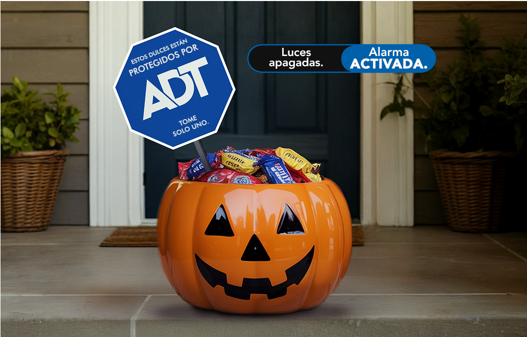 Cubo de dulces de Halloween en la puerta con letrero de jardín ADT especial para vacaciones