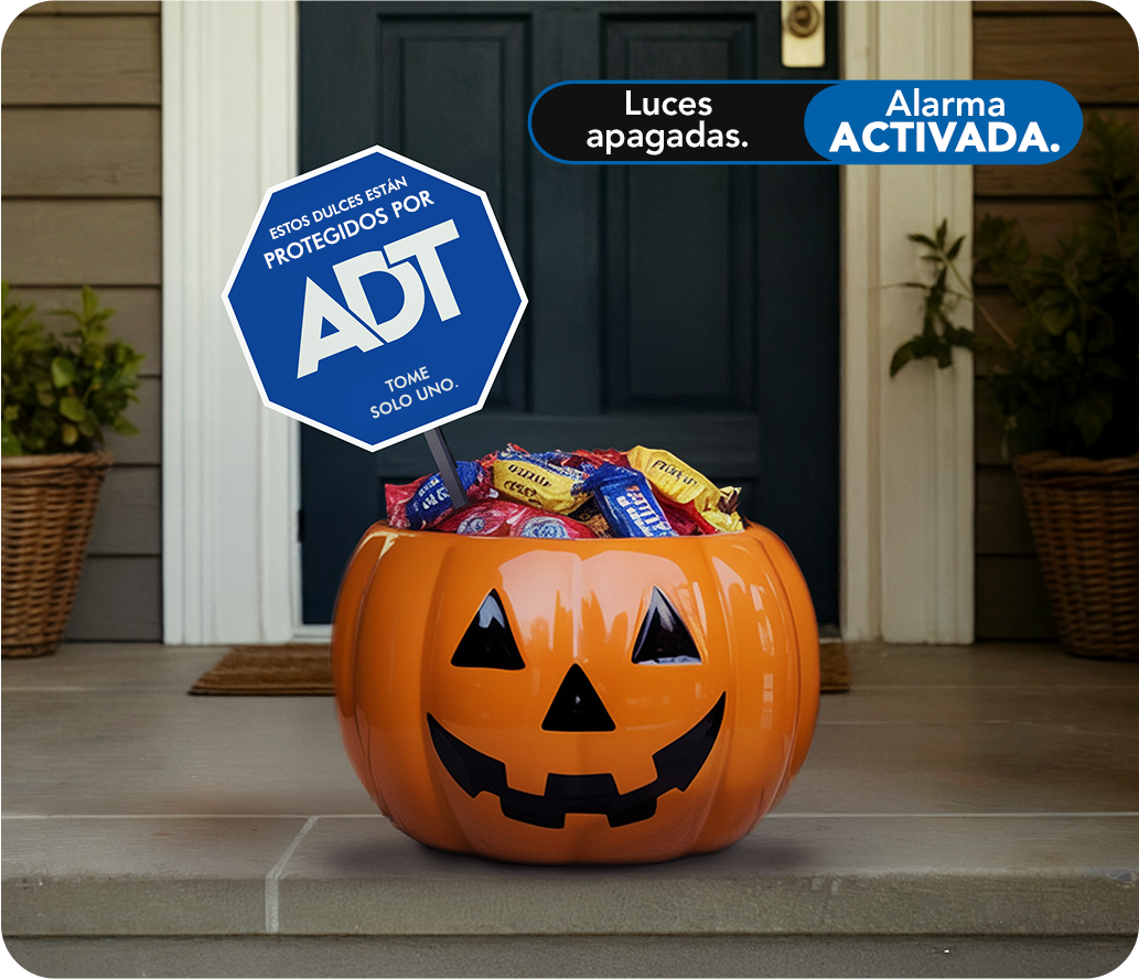 Cubo de dulces de Halloween en la puerta con letrero de jardín ADT especial para vacaciones